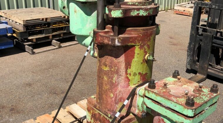 old rusted willett pump on a pallet in a warehouse.