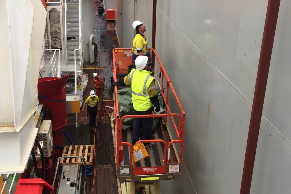 WATMAR engineers performing Engineering Inspections from a scissor lift, high up the side of a building on board a vessel